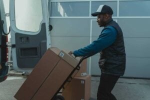 A man moves order boxes from a van